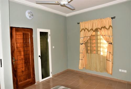 a room with a ceiling fan and a window at Villa Beach Avepozo Lome in Lomé