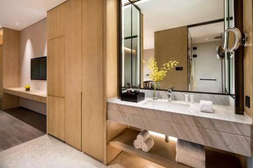 a bathroom with a sink and a large mirror at InterContinental Xi'an Hi-Tech Zone in Xi'an