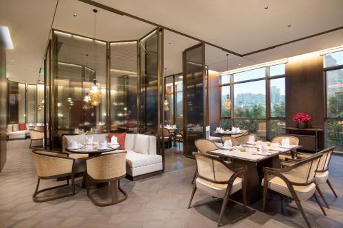 a restaurant with tables and chairs and glass walls at InterContinental Xi'an Hi-Tech Zone in Xi'an