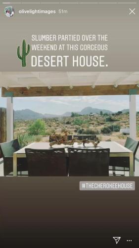 a sign for a desert house with a table and chairs at The Cherokee House in Joshua Tree in Joshua Tree