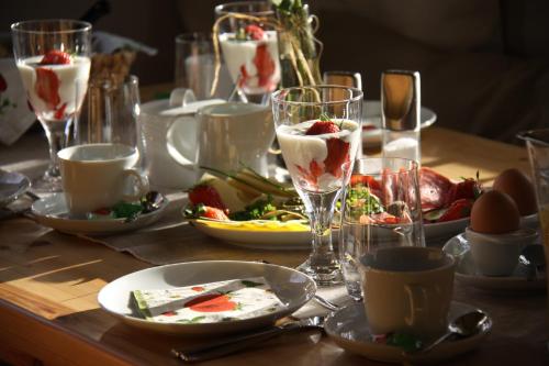 a table with plates of food and glasses of drinks at NaturApartments - Hideaway & Spa in Burg