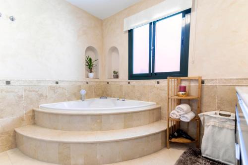 a large bathroom with a tub and a window at Luxury villa with sea views - heated pool-Jacuzzi in Benalmádena