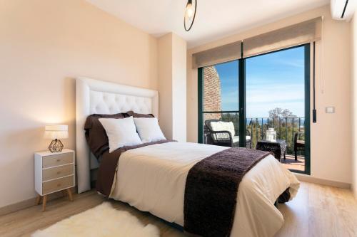 a bedroom with a bed and a large window at Luxury villa with sea views - heated pool-Jacuzzi in Benalmádena