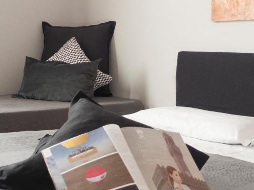 a book sitting on top of a bed with a chair at Relais Stibbert Florence in Florence