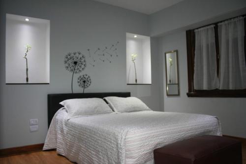 Villa Adelina的住宿－TuHabitat BA，卧室配有一张墙上鲜花的床