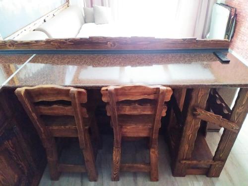 a wooden table with two stools and a mirror at Light Apartments in Gudauri