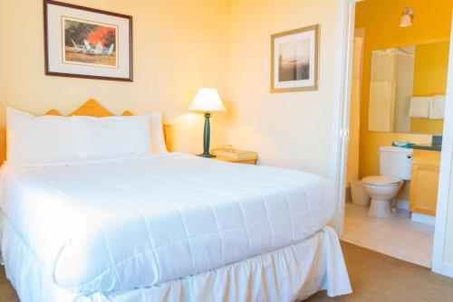 a bedroom with a large white bed and a bathroom at Long Trail House Condominiums at Stratton Mountain Resort in Stratton Mountain