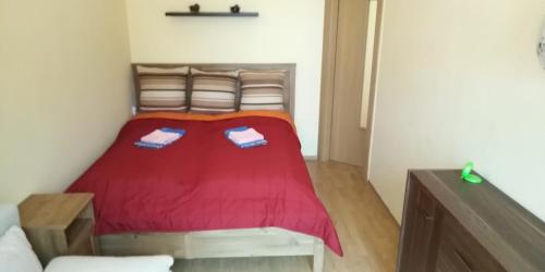 una camera con un letto con copriletto rosso di Apartmán Karin a Oščadnica