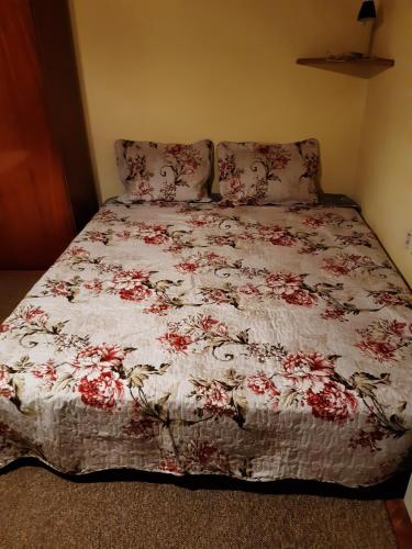 a bed with a floral comforter in a bedroom at Vysoké Tatry - Svit in Svit