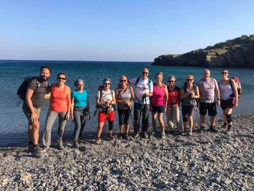 un gruppo di persone in piedi sulla spiaggia di Dorana Apartments & Trekking Hotel a Diafani