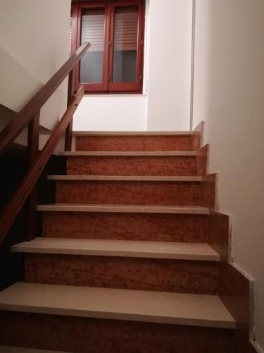 a set of stairs with a door and a window at Piazza San Giorgio in Dolianova