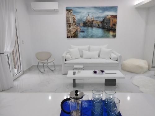 ein Wohnzimmer mit einem weißen Sofa und einem Tisch in der Unterkunft Despina's Lux apt Downtown in Iraklio