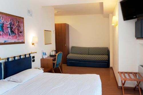 a hotel room with a couch and a television at Hotel International in San Benedetto del Tronto