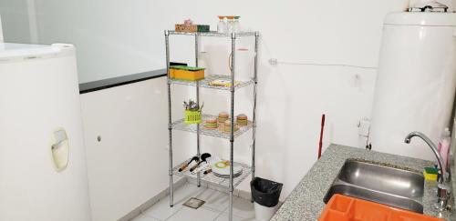 Un estante de metal en una cocina al lado de un fregadero. en Edificio Huayra, en La Rioja