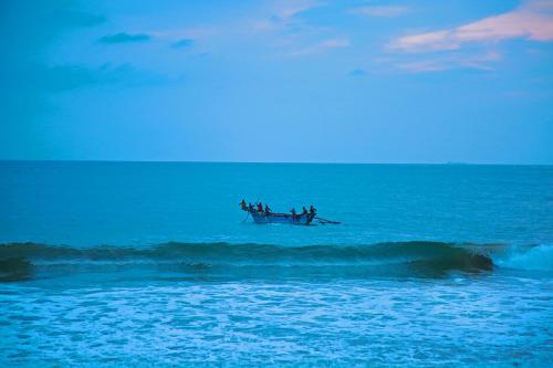 a group of people in a boat in the ocean at Brother's Beach Home in Galle