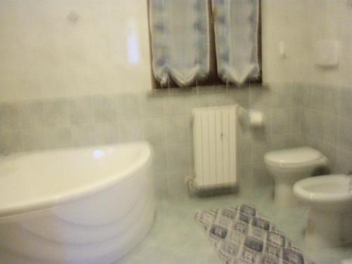 y baño con aseo blanco y lavamanos. en Quattroventi casa vacanza en Montecchio