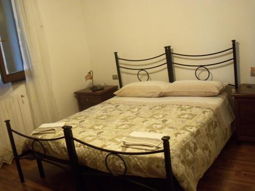 1 dormitorio con 1 cama grande y suelo de madera en Quattroventi casa vacanza en Montecchio