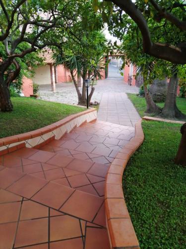a walkway in a park with trees and grass at Piazza San Giorgio in Dolianova