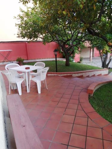 a patio with two white chairs and a table at Piazza San Giorgio in Dolianova