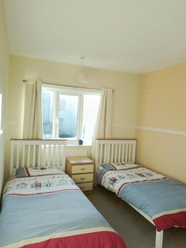 two beds in a room with a window at The Bays in Bridlington