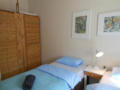 a bedroom with two beds and a night stand with a lamp at Amber Lagoon Backpackers Lodge in Vleirivier