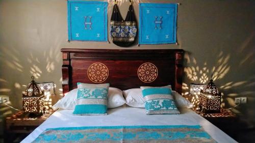 a bedroom with a bed with blue and white pillows at R´Mila Medina Fez in Fès