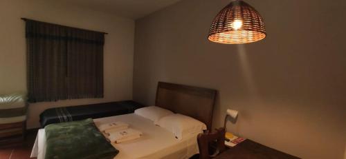 a small bedroom with a bed and a lamp at Pousada Fazenda Sant’Ana in Vinhedo