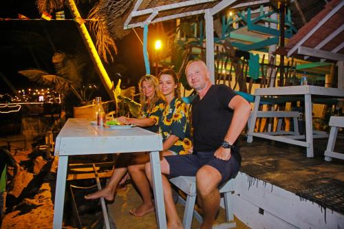 a man and two women sitting at a table at Brother's Beach Home in Galle