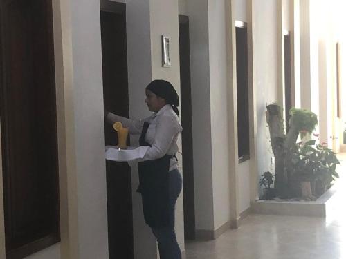 a woman standing in a hallway holding a candle at Hotel Abadias De Zapatoca in Zapatoca