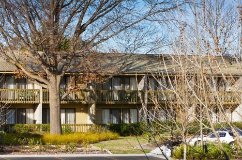 a building with a tree in front of it at Tall Trees Ainslie Motel in Canberra