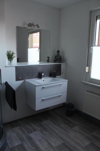 a bathroom with a white sink and a mirror at Ferienwohnung Funke F1 für Monteure in Apolda