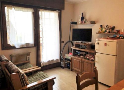 a living room with a refrigerator and a television at Condominio Ginepro in Carisolo