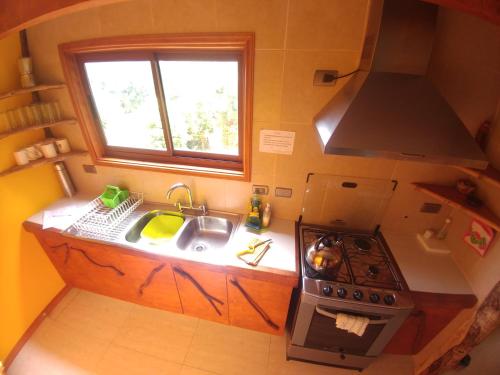 a small kitchen with a stove and a sink at La Rueda del Chucao in Valdivia