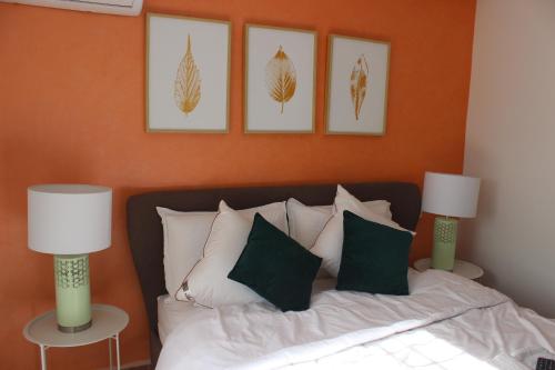 a bedroom with a bed with pillows and two lamps at New Fez Apartments in Fez