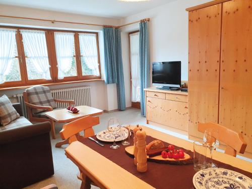 ein Wohnzimmer mit einem Tisch und ein Wohnzimmer mit einem TV in der Unterkunft Haus Andrea in Fischen im Allgäu