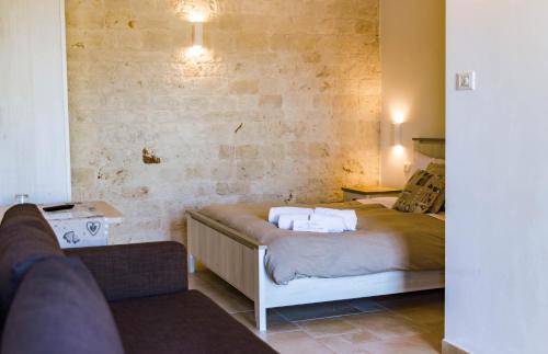 a hotel room with a bed and a couch at Relais La Masseriola in Castellana Grotte
