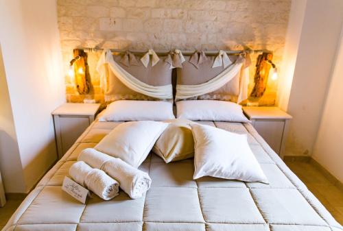 a bedroom with a bed with white pillows at Relais La Masseriola in Castellana Grotte