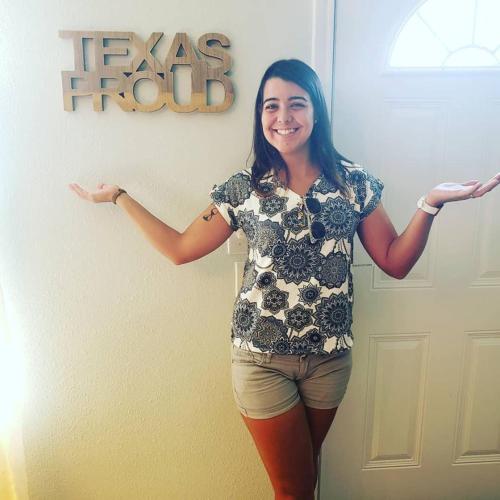 a woman is standing in front of a door at Wanderstay Houston Hostel in Houston