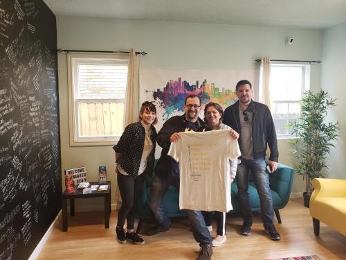 a group of people holding up a t shirt at Wanderstay Houston Hostel in Houston