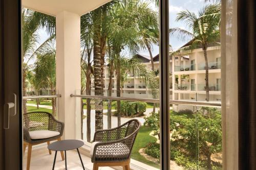 a view from the balcony of a hotel with chairs and a table at Secrets La Romana All-Inclusive Adult Only Resort & Spa in Bayahibe