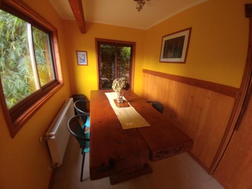 a wooden table in a room with a window at La Rueda del Chucao in Valdivia