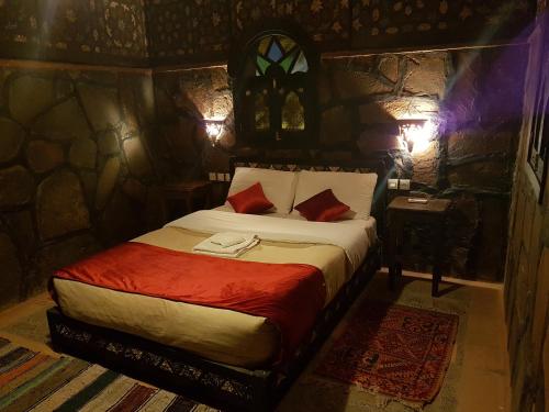 a bedroom with a bed in a stone room at Rose du Sable in Agdz