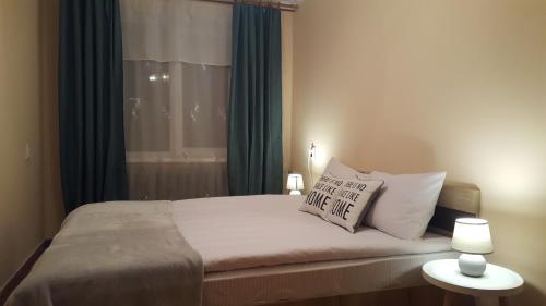 um quarto com uma cama com duas almofadas e uma janela em Best Apartment Naukova em Lviv
