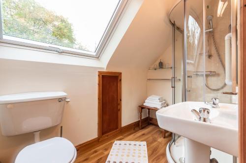 bagno con lavandino, servizi igienici e finestra. di An Bruachan B&B a Kenmare