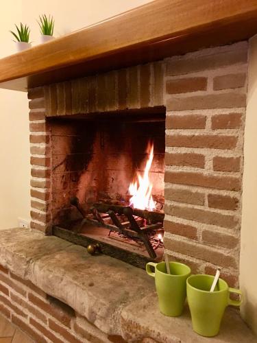 a brick fireplace with two green cups in front of it at L'arciere in Celano