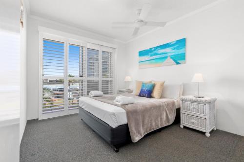 a bedroom with a bed, a desk and a window at The Burlington Holiday Apartments in Maroochydore