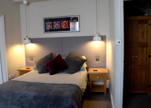 a bedroom with a bed with two night stands and two tables at Westham in Warwick