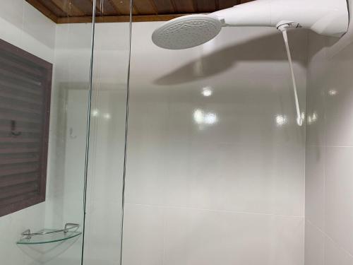 una doccia con una porta in vetro in un bagno di Apartamento com Vista do Mar em Residencial com Piscina a Florianópolis