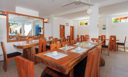 a dining room with a large wooden table and chairs at Hotel La Casa de Judy in Puerto Ayora