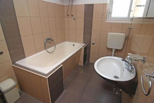 ein Badezimmer mit einem Waschbecken, einer Badewanne und einem WC in der Unterkunft Apartment Bela1 - close to the beach in Trogir